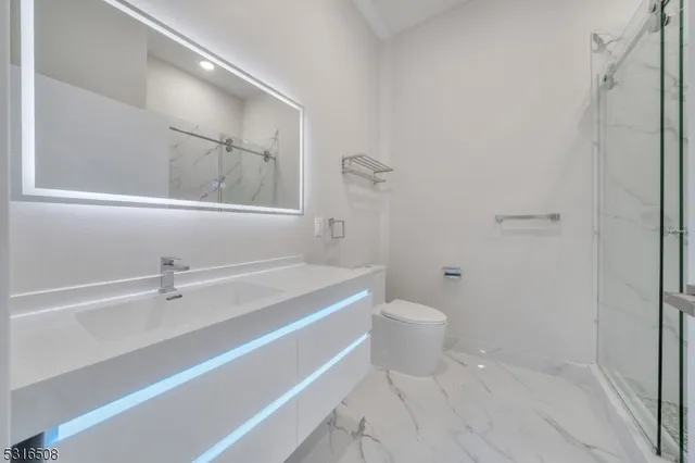 a bathroom with a sink a toilet and a mirror
