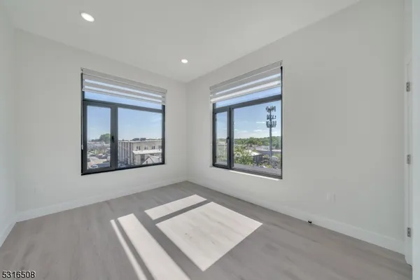 a view of an empty room with a window and a dresser