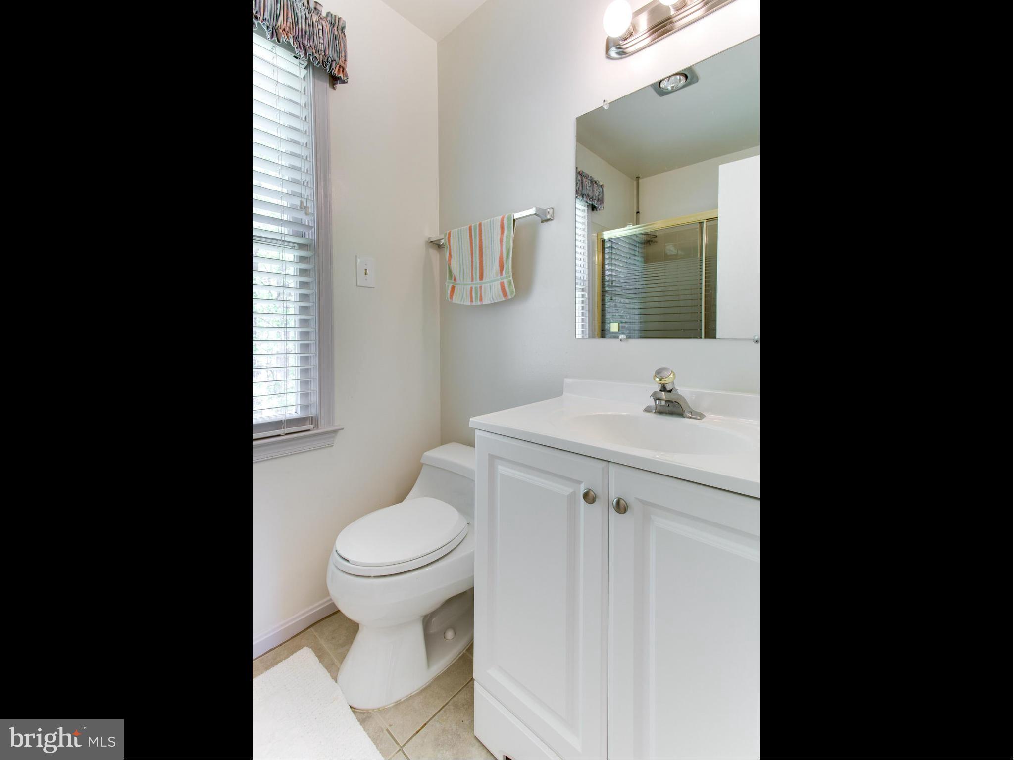 10 Deckman Court Silver Spring, MD 20906 - Photo 21 of 25 a bathroom with a granite countertop toilet a sink and a mirror