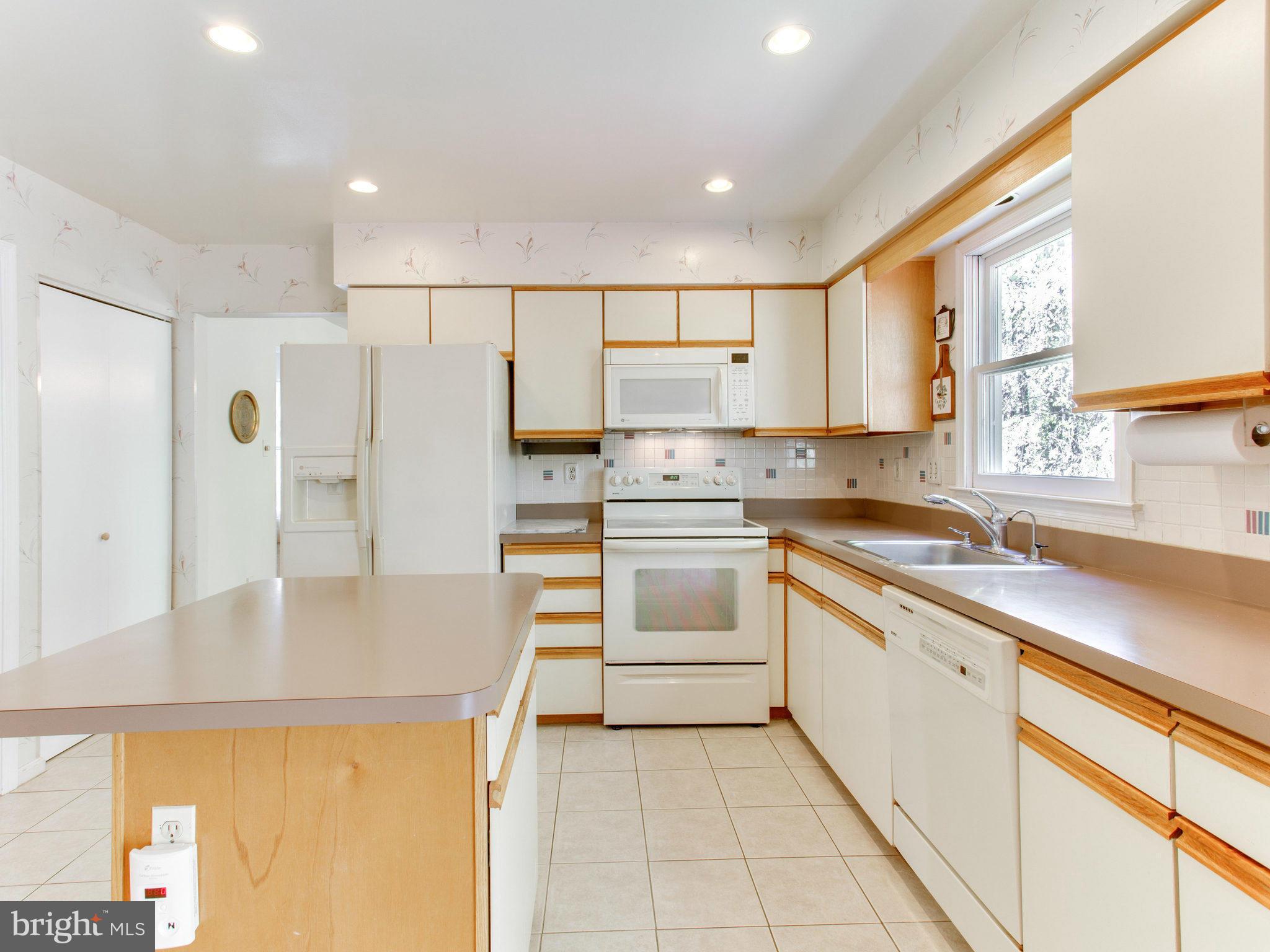 10 Deckman Court Silver Spring, MD 20906 - Photo 10 of 25 a kitchen with white cabinets and white appliances