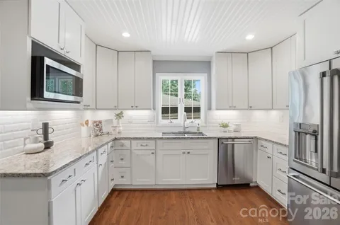 a kitchen with stainless steel appliances granite countertop a sink stove and microwave