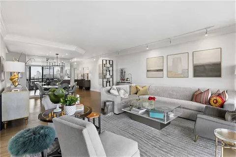 a living room with furniture and a dining table with wooden floor