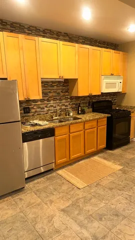 a kitchen with stainless steel appliances granite countertop a sink and a stove