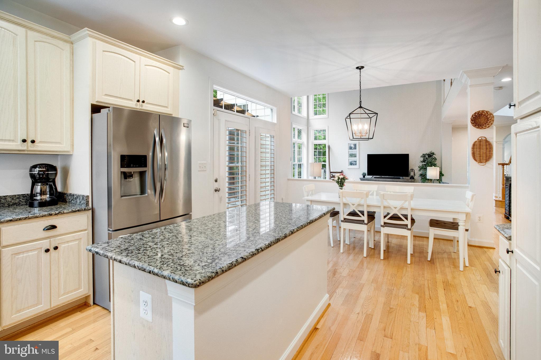 18565 Kerill Road Triangle, VA 22172 - Photo 33 of 59 a kitchen with stainless steel appliances kitchen island granite countertop a table chairs stove and refrigerator