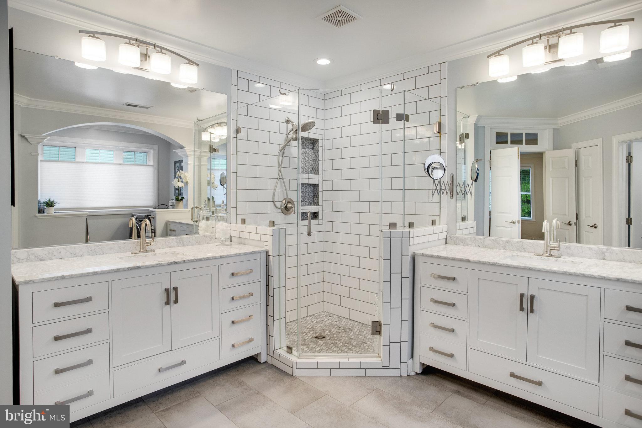 18565 Kerill Road Triangle, VA 22172 - Photo 38 of 59 a bathroom with a double vanity sink a large mirror and shower