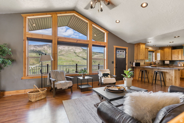 2013 North River View Road Huntsville, UT 84317 - Photo 7 of 53 Living area featuring a mountain view, wood finished floors, a textured ceiling, and a chandelier