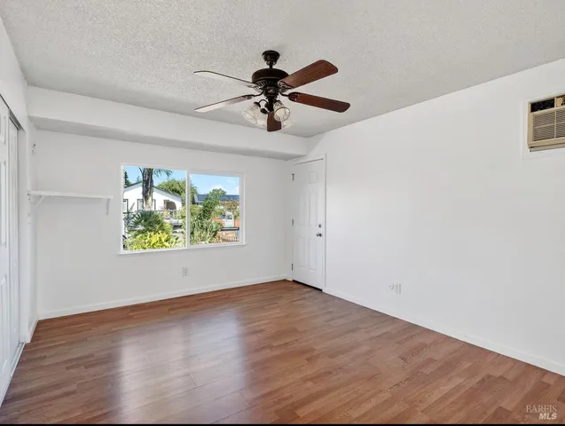 a view of an empty room with a fireplace and a window