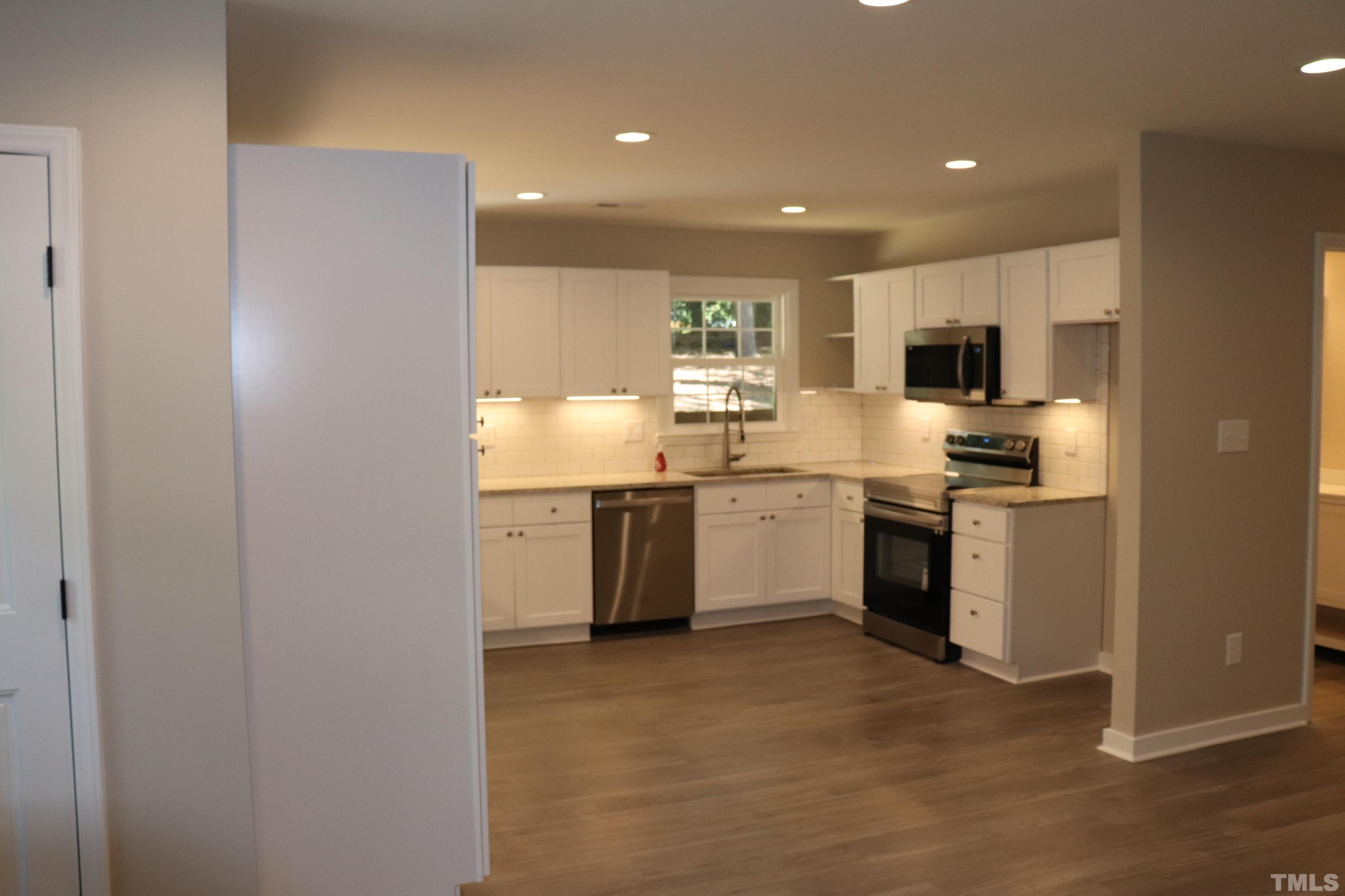 1108 Wyldewood Road Durham, NC 27704 - Photo 12 of 35 a kitchen with a sink cabinets and stainless steel appliances