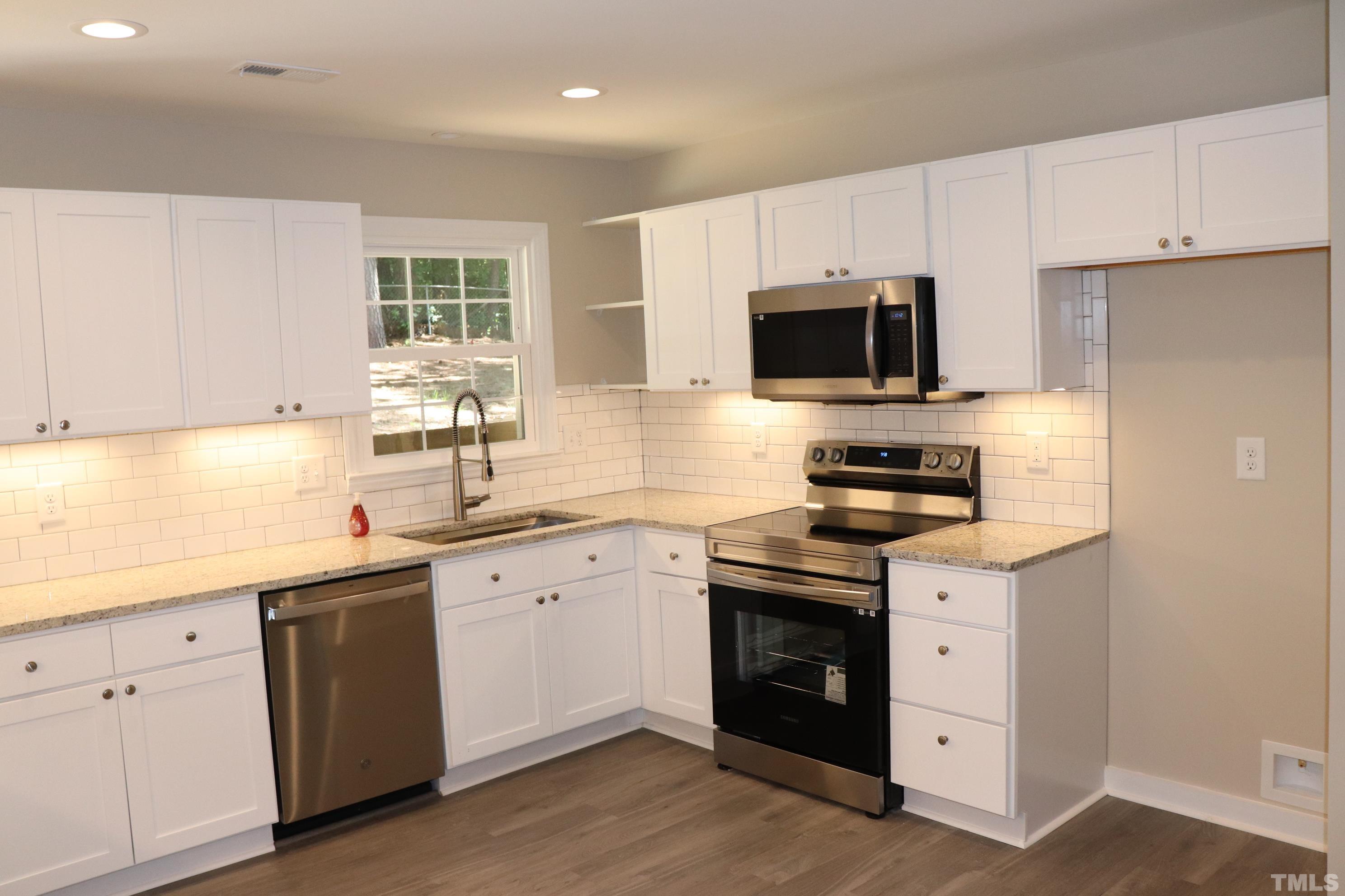 1108 Wyldewood Road Durham, NC 27704 - Photo 13 of 35 a kitchen with a sink stove and microwave