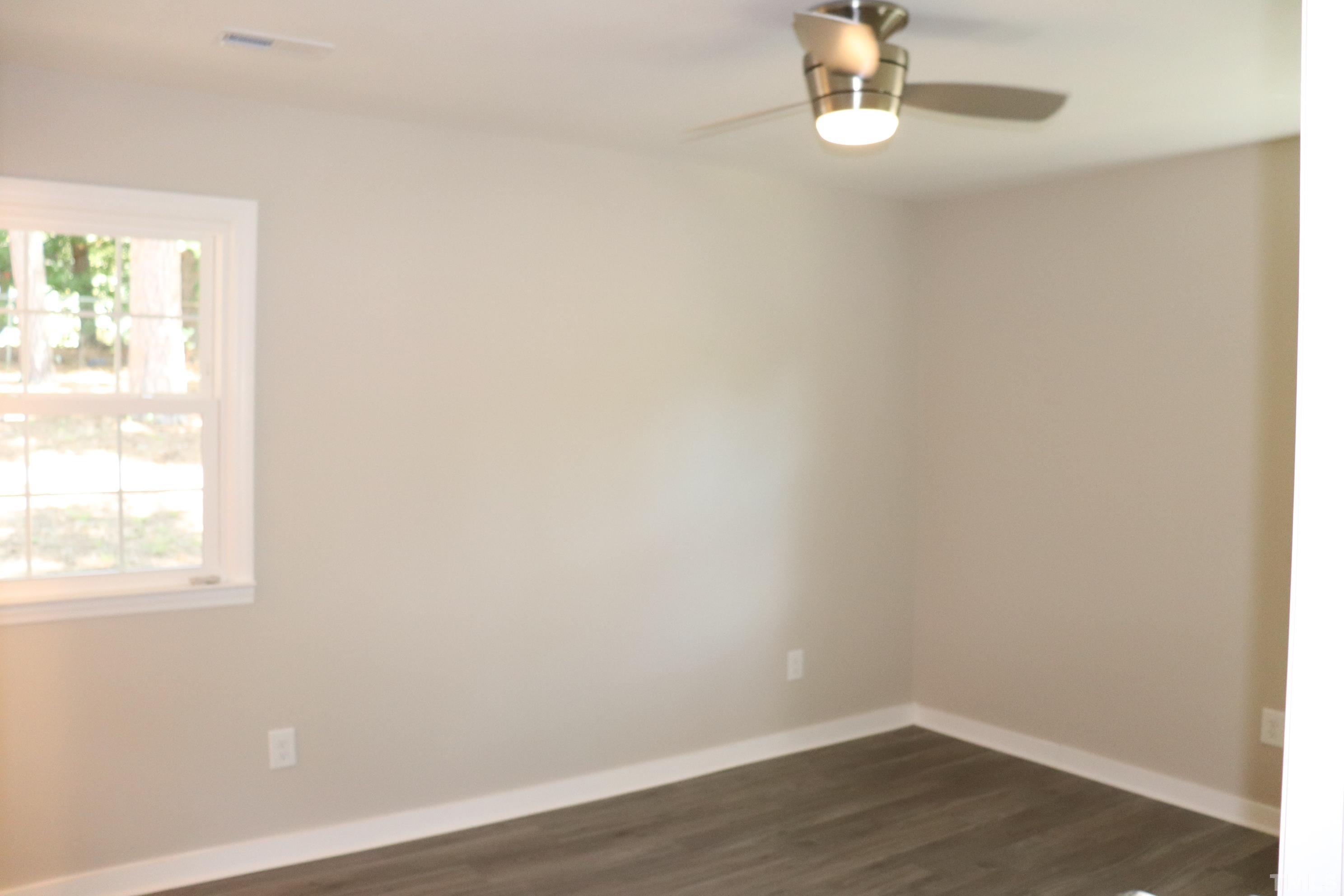1108 Wyldewood Road Durham, NC 27704 - Photo 27 of 35 an empty room with wooden floor and window