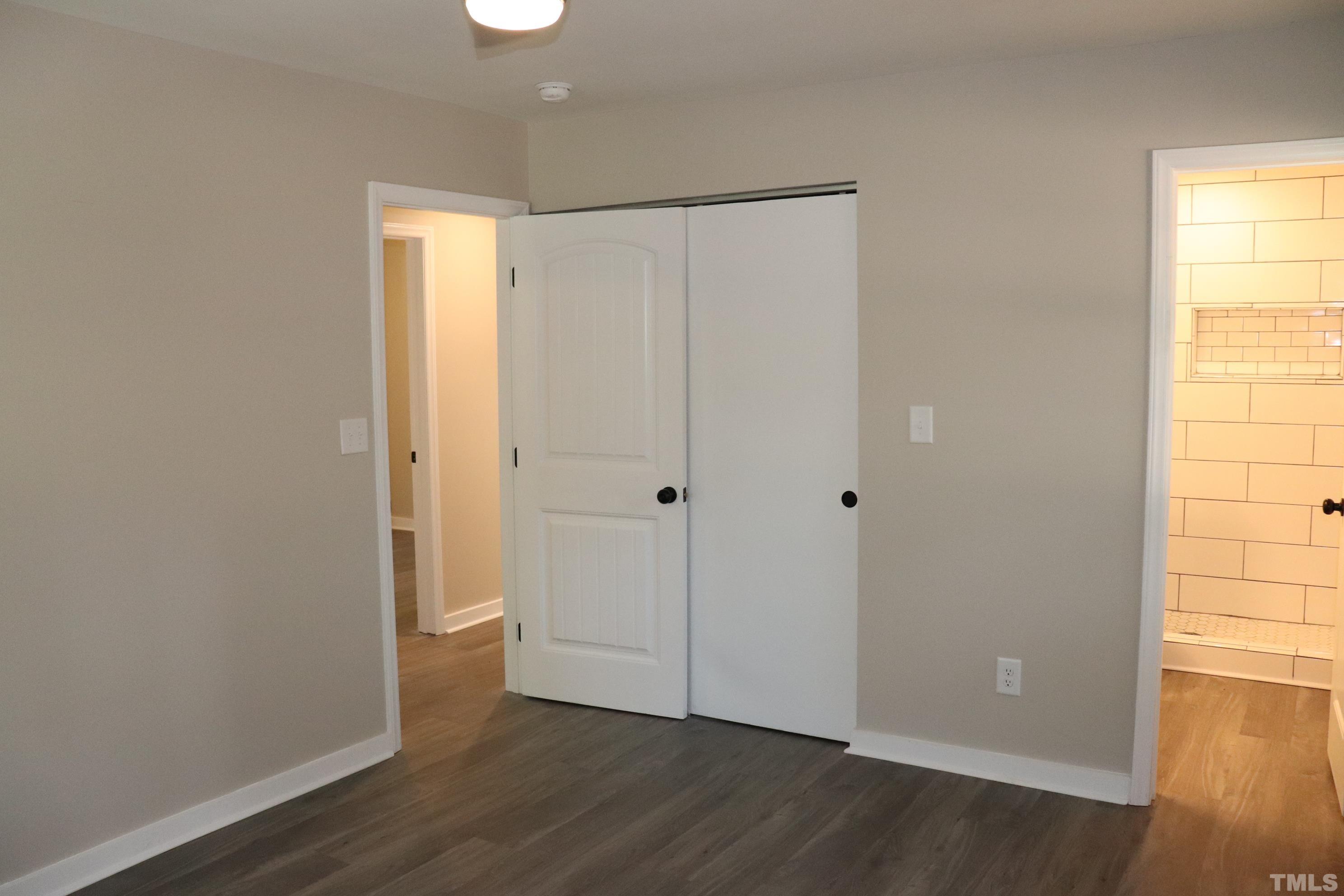 1108 Wyldewood Road Durham, NC 27704 - Photo 32 of 35 a view of an empty room with wooden floor and a window