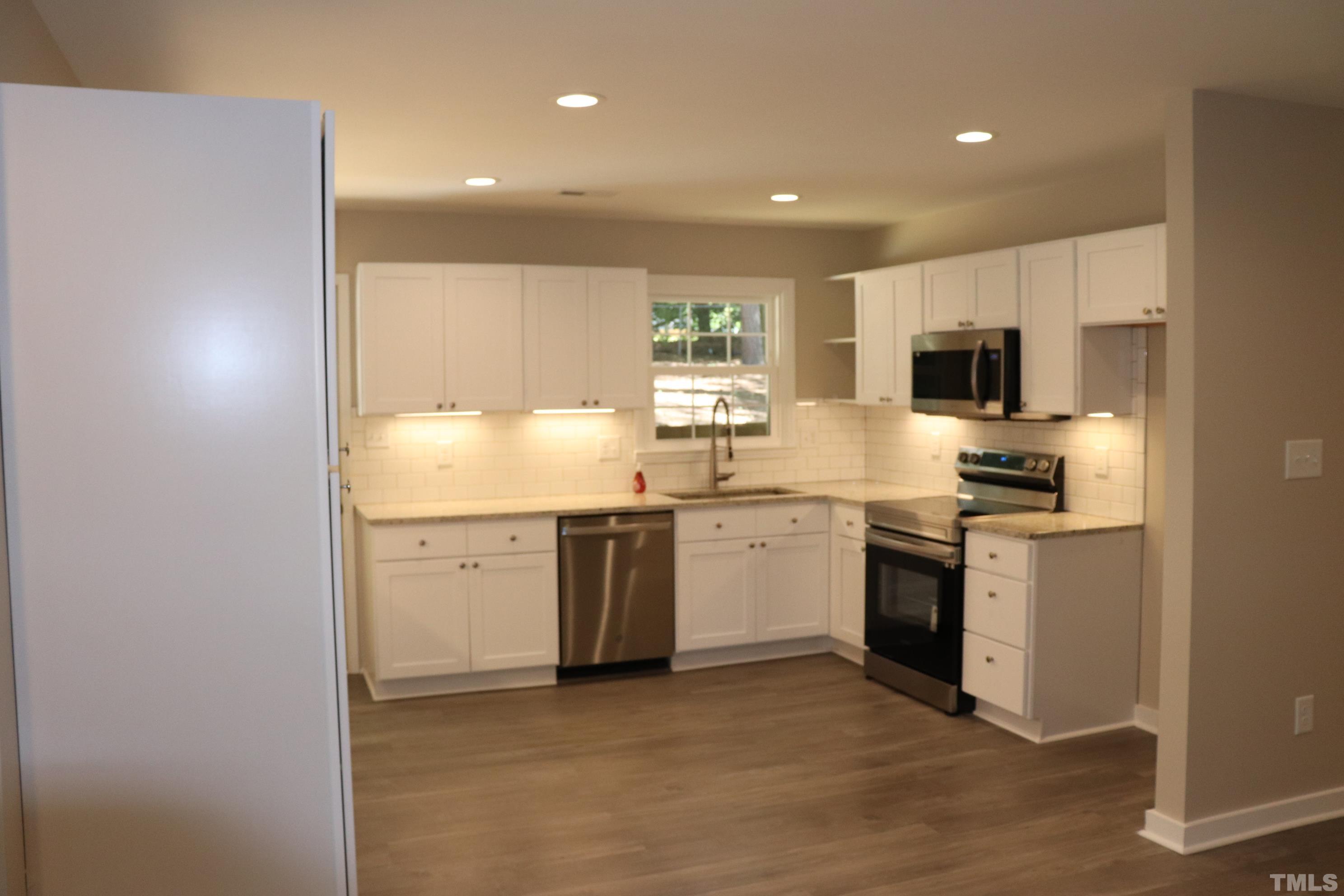 1108 Wyldewood Road Durham, NC 27704 - Photo 10 of 35 a kitchen with a sink stove and refrigerator