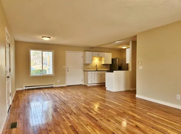 a view of a kitchen with wooden floor and a window