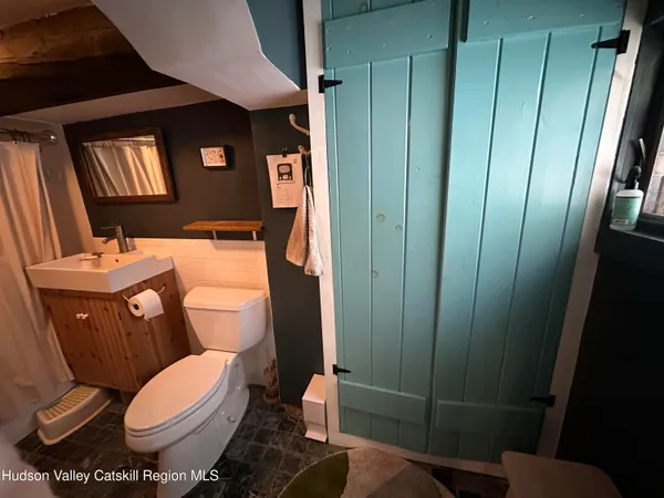 a bathroom with a toilet a sink and mirror