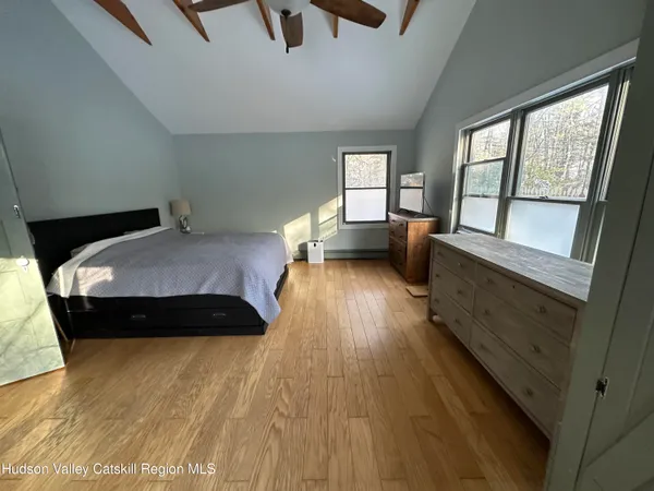 a bedroom with a bed and a large window