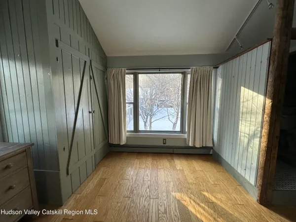 an empty room with wooden floor and a window