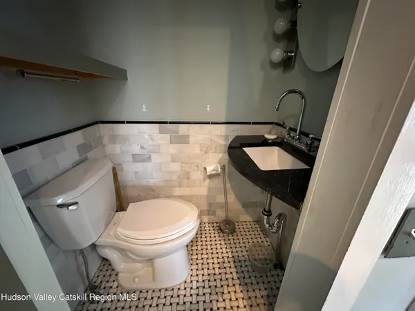 a bathroom with a toilet sink and mirror