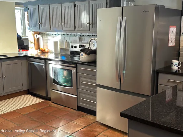 a kitchen with stainless steel appliances granite countertop a refrigerator a stove and a sink