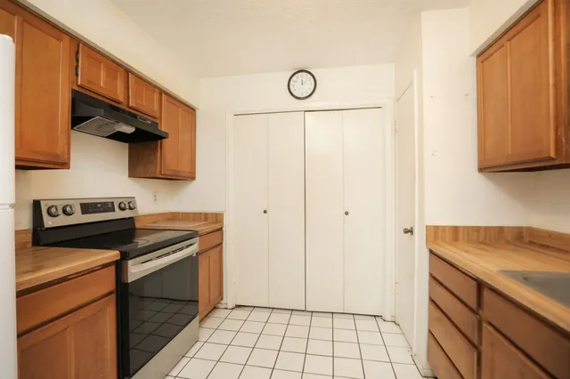 a kitchen with a stove cabinets and a refrigerator