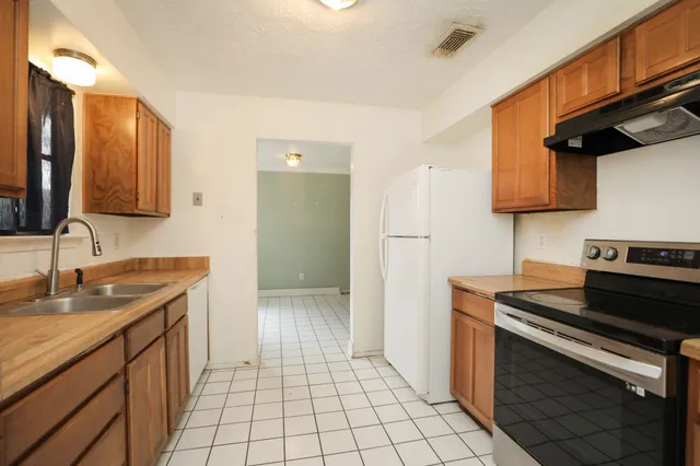 a kitchen with a sink stove and cabinets
