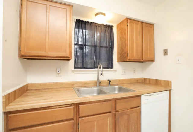 a kitchen with a sink cabinets and a wooden floor