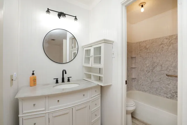 a bathroom with a sink a toilet and a mirror