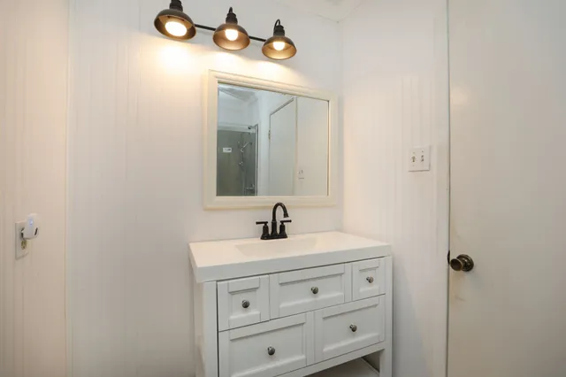 a bathroom with a sink vanity and mirror