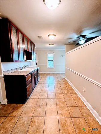 a large white kitchen with a stove a sink and a refrigerator