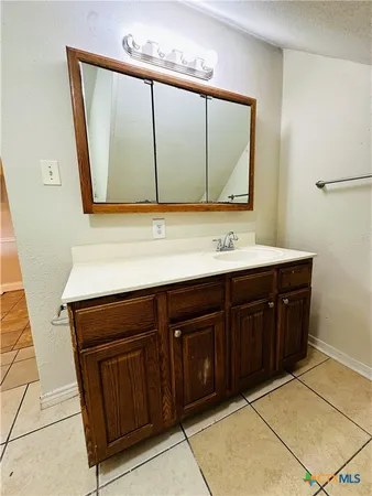 a bathroom with a sink vanity and a mirror