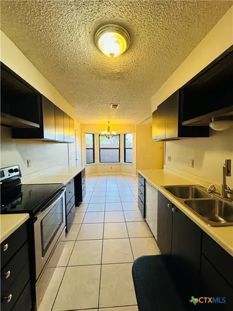 a kitchen with a sink and a stove top oven