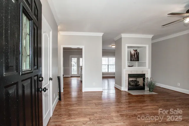a view of a livingroom with wooden floor and a fireplace