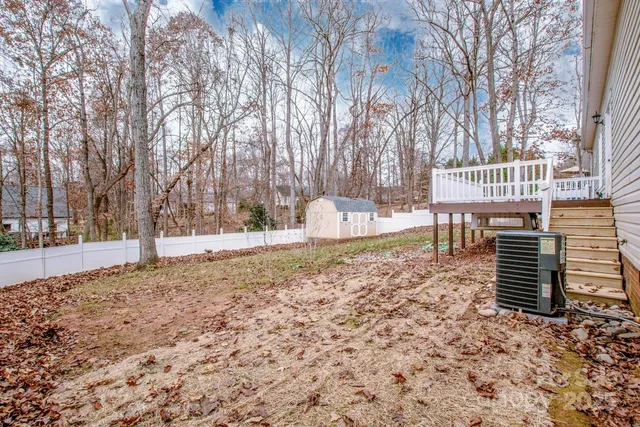 a view of a yard with plants and trees
