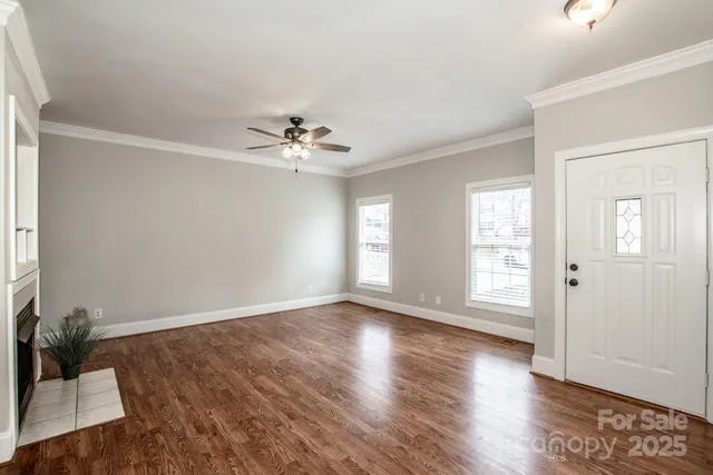 an empty room with wooden floor and window