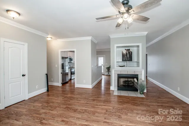 a view of a livingroom with a fireplace a chandelier and wooden floor