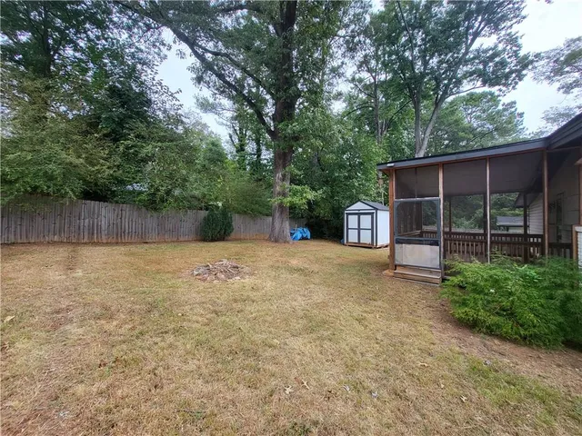 a view of a house with backyard and a tree