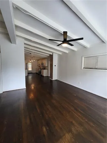 a view of a hallway with wooden floor and livingroom