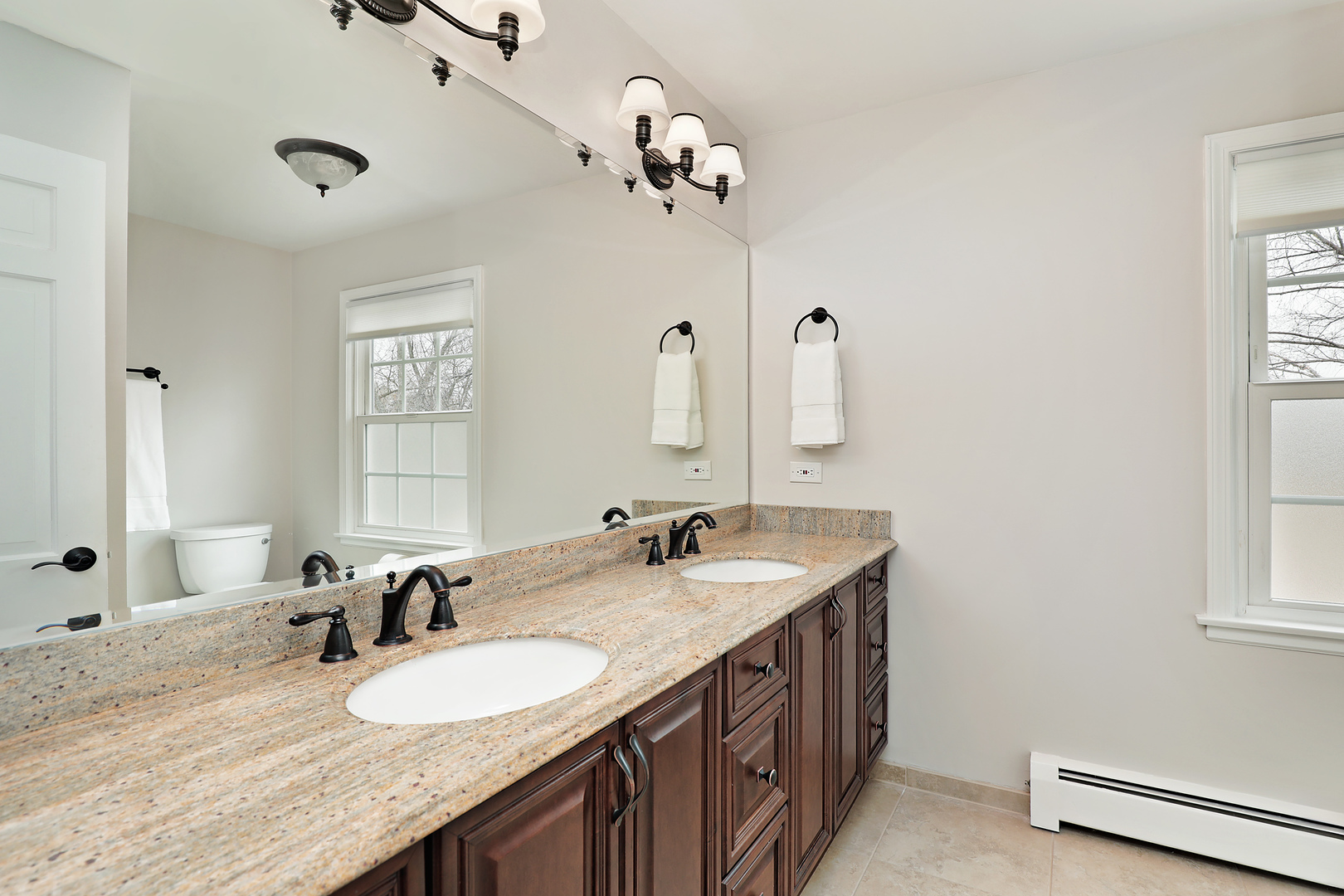 2915 Shannon Road Northbrook, IL 60062 - Photo 19 of 33 a bathroom with a granite countertop sink a large mirror and a shower