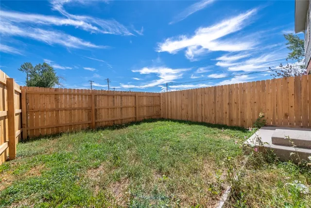 a view of backyard with wooden fence