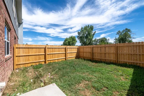 a view of backyard with wooden fence