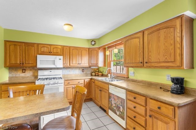 815 North Road Niles, OH 44446 - Photo 11 of 27 Kitchen with light tile patterned floors, backsplash, white appliances, and sink