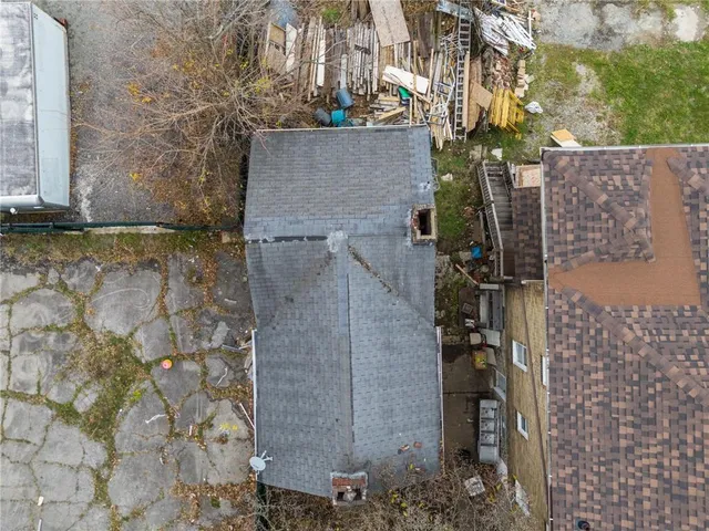 a brick building with a bench and trees