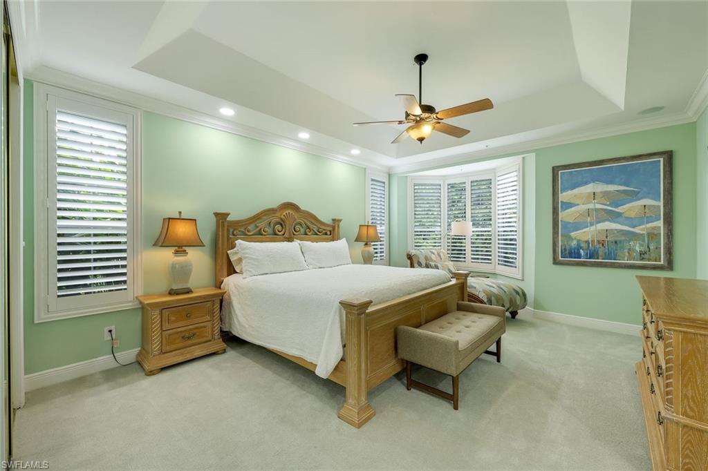 269 Colonade Circle, Unit 2802 Naples, FL 34103 - Photo 24 of 50 a bedroom with a bed and a chandelier