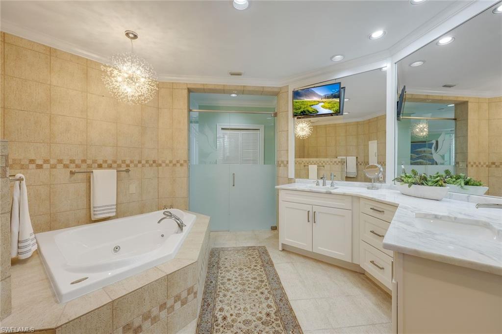 269 Colonade Circle, Unit 2802 Naples, FL 34103 - Photo 28 of 50 a spacious bathroom with a granite countertop tub sink shower and mirror