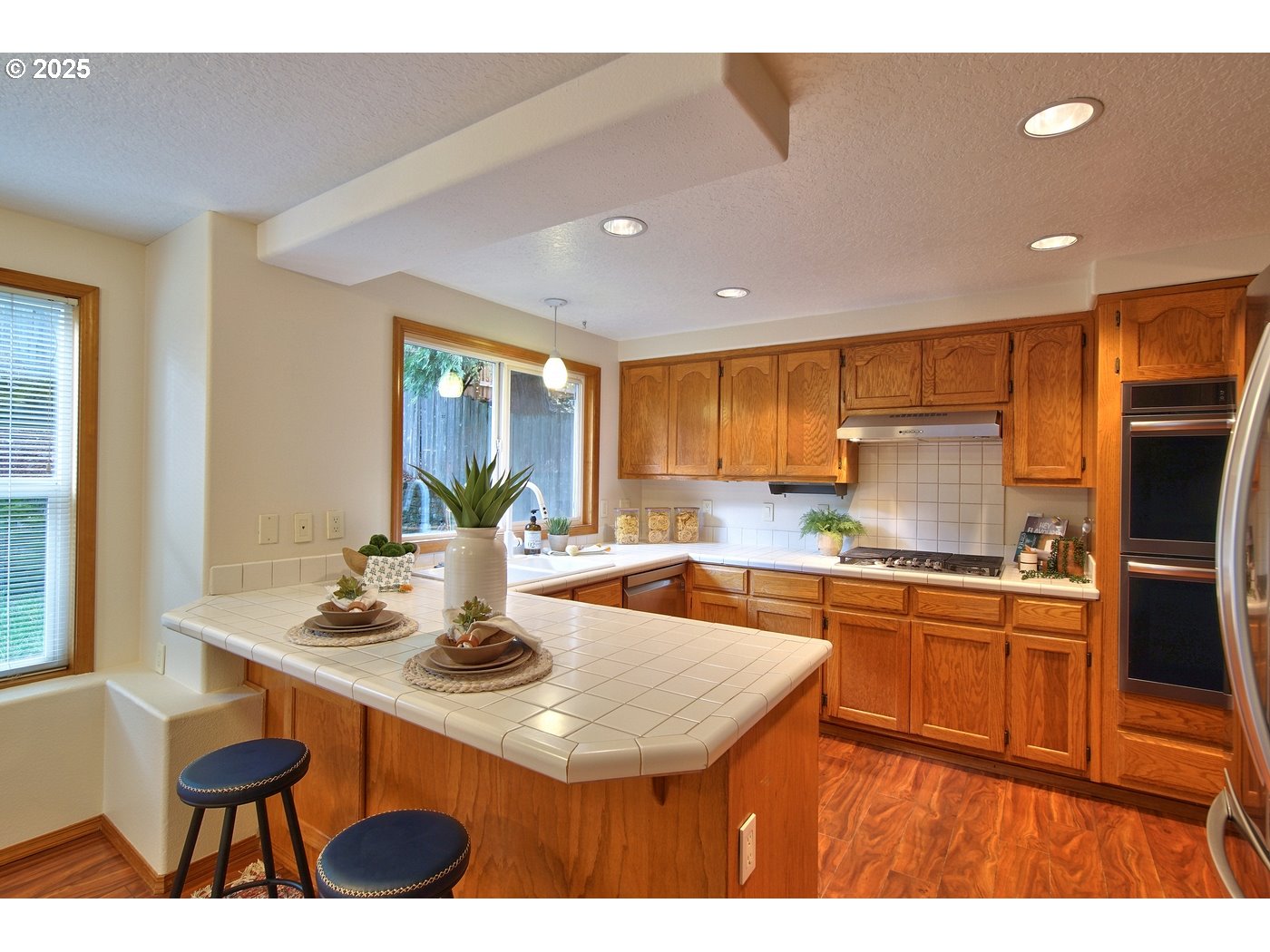 8411 Southwest 184th Loop Beaverton, OR 97007 - Photo 9 of 34 a kitchen with stainless steel appliances granite countertop a sink a stove a refrigerator cabinets and living room view