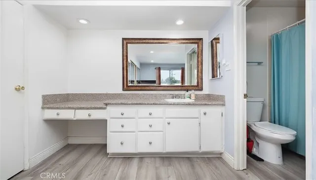 a bathroom with a sink a toilet and a mirror