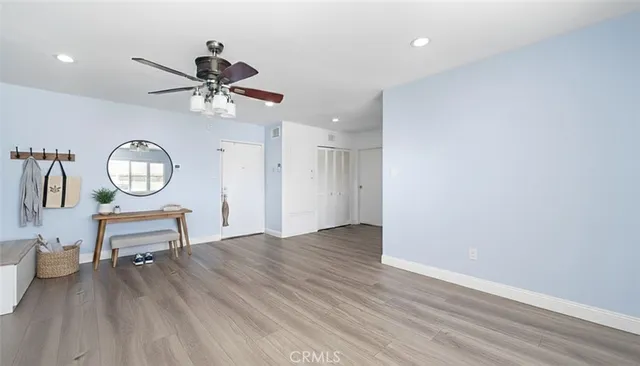 a view of a room with a wooden floor and a ceiling fan