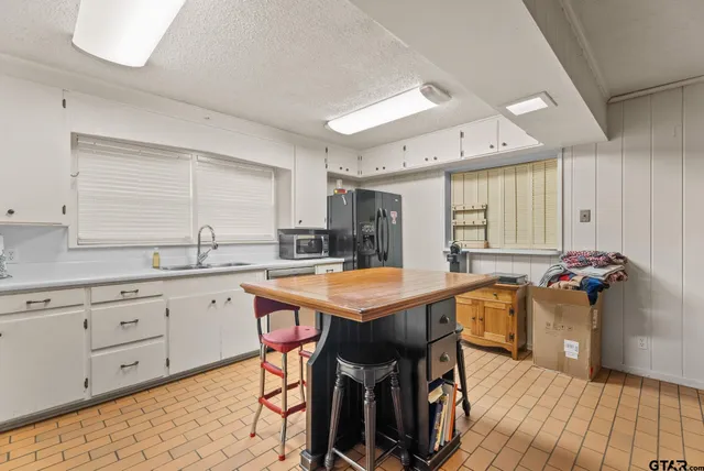 a kitchen with stainless steel appliances granite countertop a stove a sink and white cabinets