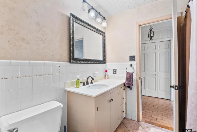 a bathroom with a sink a toilet and a mirror