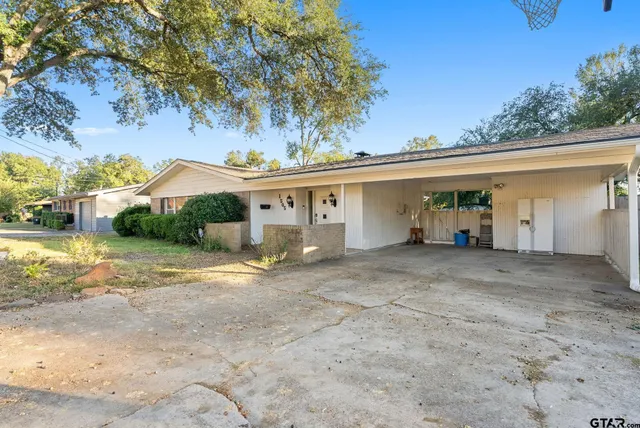 a view of a house with a backyard and a tree