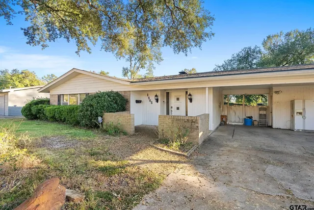 a view of a house with backyard and a tree